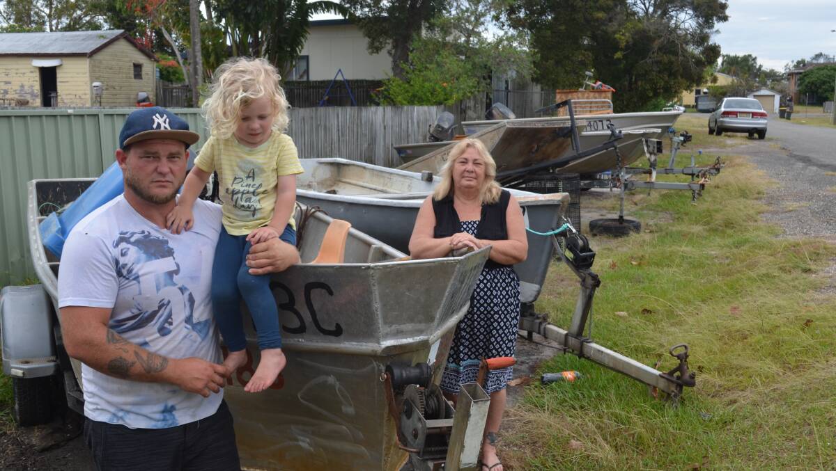 Devastated: Donna Cook, her son Jamie and his son Kayden with some of the family's boats, which they say will be "worthless" following the reforms. Photo: Lachlan Leeming
