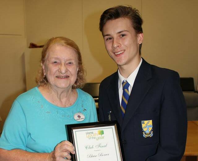 Blaise Borrer being presented his award by one of the judges, Barbara Lawson. Image via: Love Urunga Facebook.