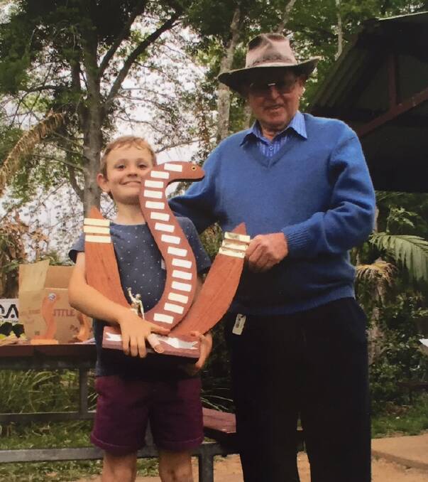 ALL SMILES: Eel Fishing Champion and winner of the “Waterhole Wal” Perpetual Trophy, Eli Williams, is presented the mighty prize by namesake and organiser. 