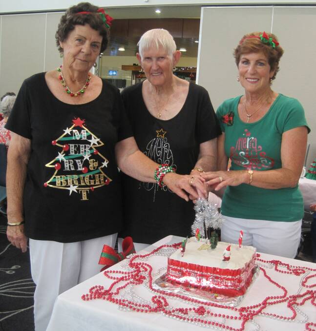 Cutting the Christmas cake: Margaret, Jean and Pat.