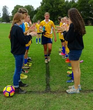 Captain Katie Thorn is clapped off the field after her last game of competitive football after six years of representing Bellingen High School.