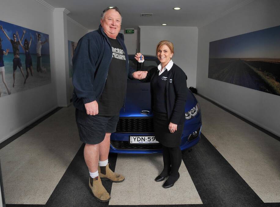 PROUD OWNER: Pete Pring-Shambler picks up his Ford Falcon XR6 ute - the last to be delivered to Wagga's Hillis Motor Group. He is with after sales and delivery co-ordinator Cheryl Fischer. Picture: Kieren L Tilly