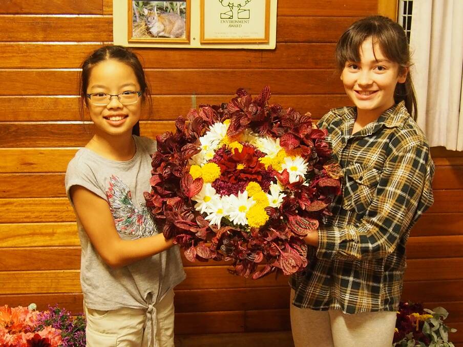 Guides Lilee Davis and Makushla Brennan showing off an ANZAC wreath