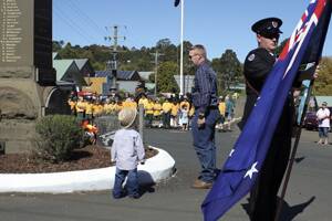 Like father like son. Two year old Cash Gibson, carrying the Australian flag, trails his father, Harley, to The Monument, at Dorrigo, to lay a wreath on behalf of Australian veterans of Timor and Afghanistan. Harley, a former regular army member, served in Timor.