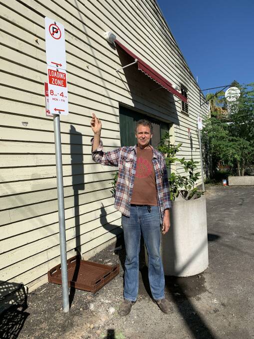 Dave Larsen pointing to the new loading zone sign