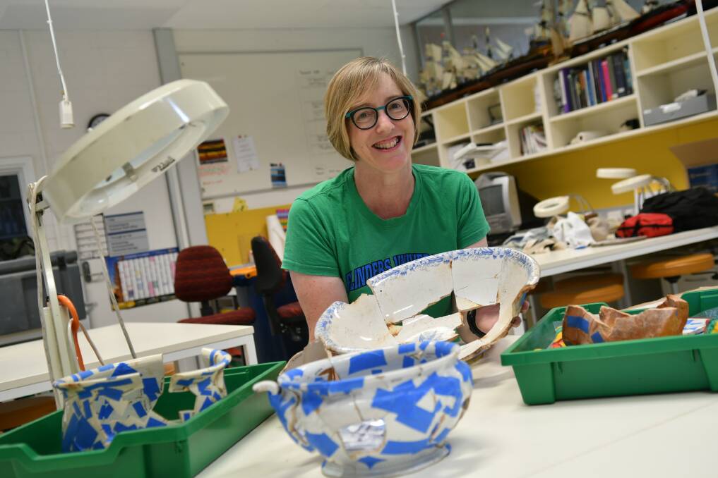 Susan Arthure with historic household artefacts from the Baker's Flat site. Photo Flinders University