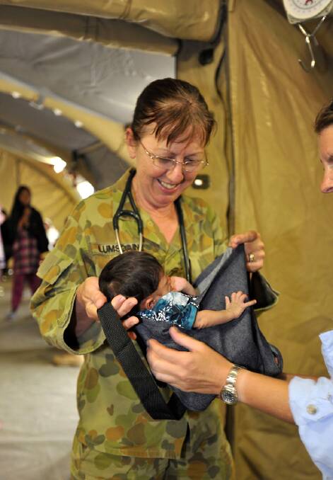 Medical Officer Major Susan Lumsdaine in 2010, preparing to weigh a Pakistani infant in the women's tent of the Australian health facility at Kot Addu, Pakistan. She was promoted after this deployment.
