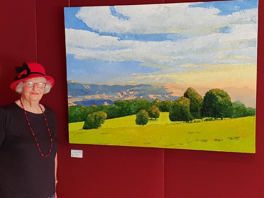 Ruth Holmes at the 'Shades of the Plateau' exhibition by Dorrigo artist Peter Mortimore in Sydney. This painting 'South over Gondwana' is of her farm below Griffiths Lookout