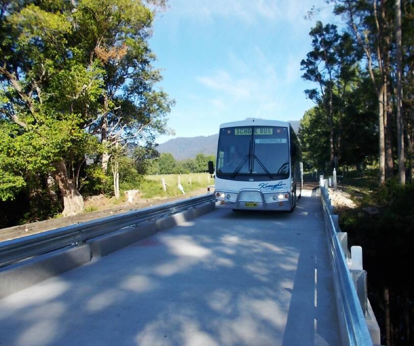 School bus traverses new steel and concrete bridge
