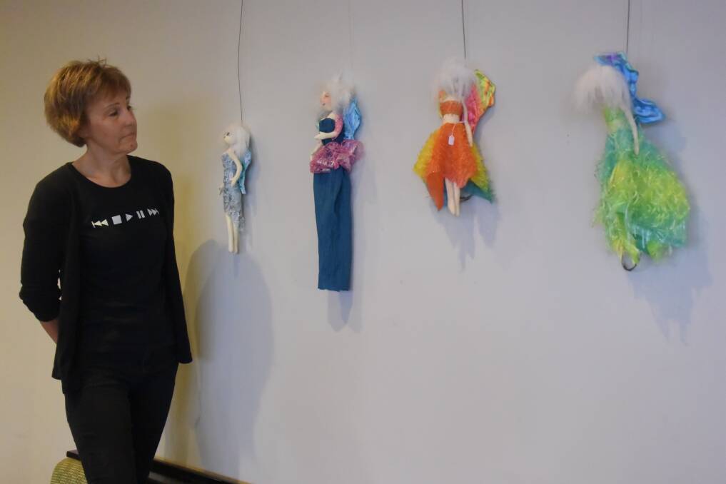 Jackie Lee with brightly coloured handmade dolls in the bistro