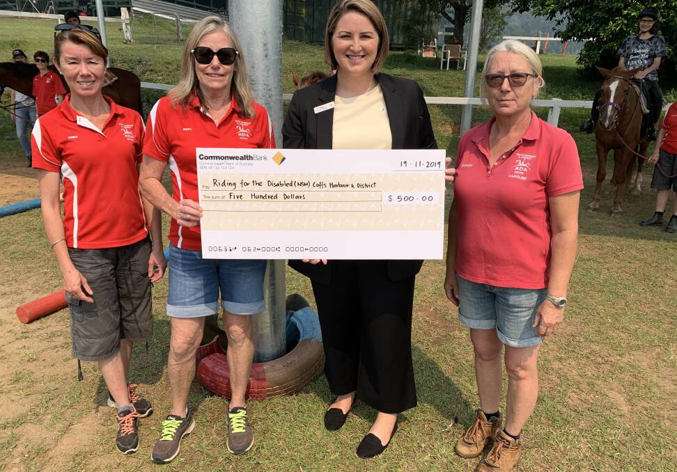 Riding for the Disabled group receiving a cheque from Kate Bear, manager of Bellingen's Commonwealth Bank