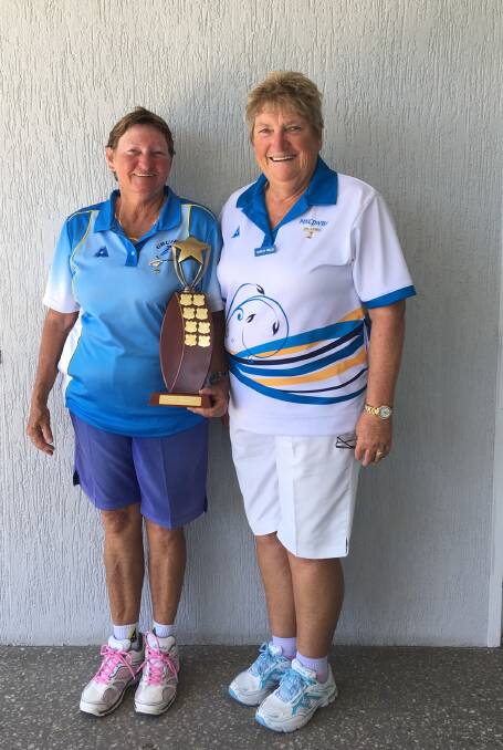 A happy and relieved Ros is pictured with her well-earned Under 5s 
trophy being warmly congratulated by District President and Urunga 
bowler Shirley Willis