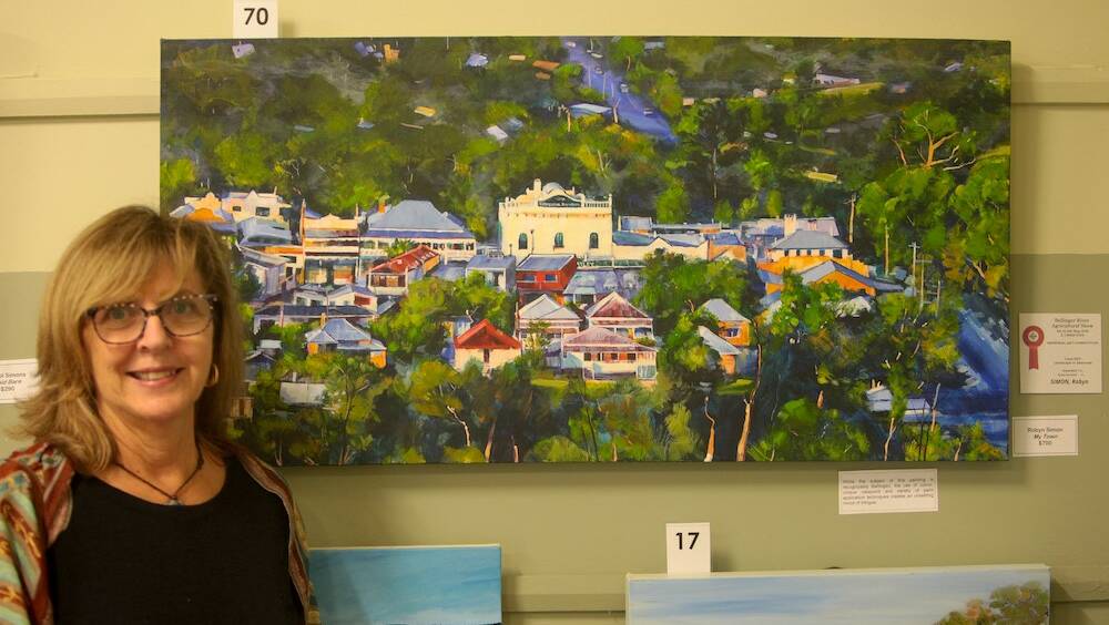 Robin Simon with her entry in the Landscape Category of last year's EJ Mantova Art Competition. The Judge said, "While the subject of this painting is recognisably Bellingen, the use of colour, unique viewpoint and variety of paint application techniques creates an unsettling mood of intrigue."