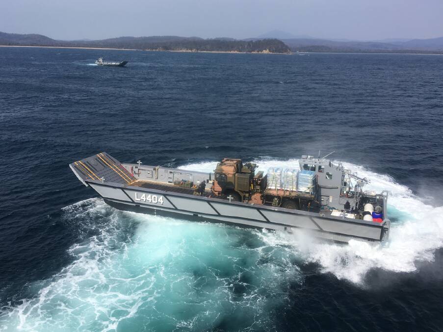 A Lighter Landing Craft from HMAS Adelaide transports an Australian Army truck ashore in the vicinity of Eden, New South Wales. Photo by CAPT Kyle Handrick