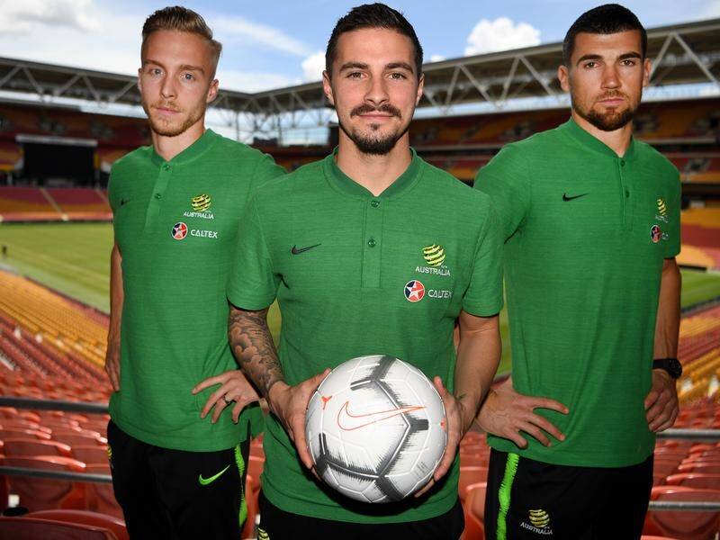 Jamie Maclaren (c) is flanked by James Jeggopose (l) and Mat Ryan at his pet venue, Suncorp Stadium.