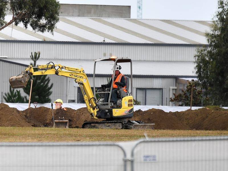 Workmen have begun digging graves in Christchurch after 50 people were killed at two mosques.