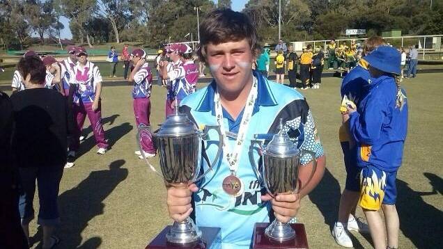 Cory Wedlock in Perth proudly displaying his medals and team trophies.